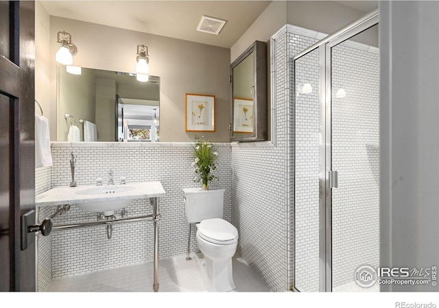 317 Wood St, Fort Collins, CO 80521 - full bath featuring toilet, a shower stall, tile walls, a sink, and tile patterned flooring