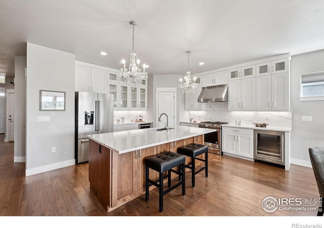 1948 Tidewater Ln, Windsor, CO 80550 - kitchen with premium appliances, beverage cooler, a chandelier, a sink, and under cabinet range hood