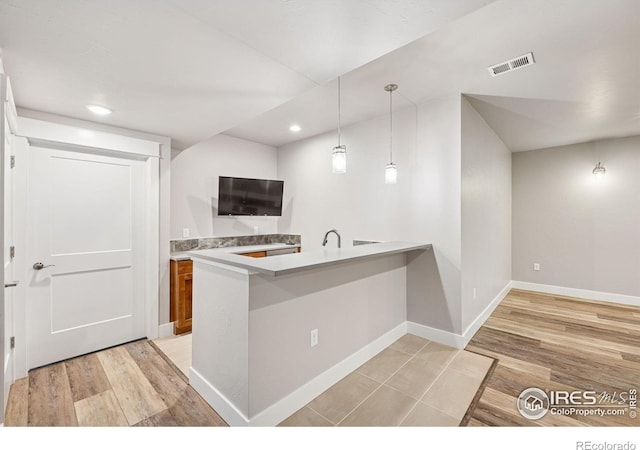 1948 Tidewater Ln, Windsor, CO 80550 - kitchen with baseboards, a peninsula, recessed lighting, decorative light fixtures, and light countertops