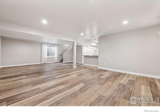 1948 Tidewater Ln, Windsor, CO 80550 - basement with light wood finished floors, baseboards, recessed lighting, and stairway