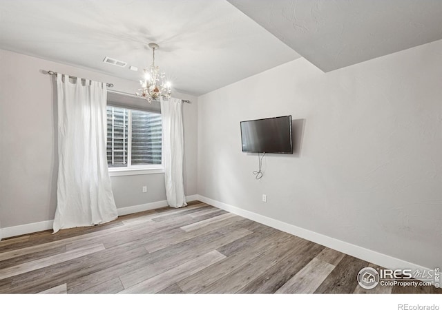 1948 Tidewater Ln, Windsor, CO 80550 - unfurnished living room featuring wood finished floors, baseboards, and a chandelier