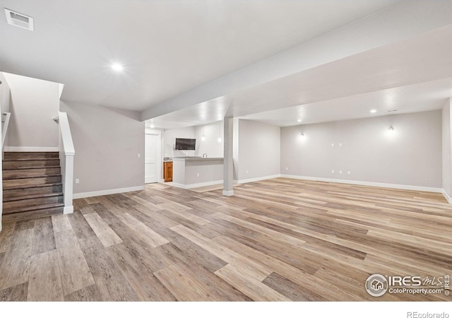 1948 Tidewater Ln, Windsor, CO 80550 - unfurnished living room featuring stairway, light wood-type flooring, baseboards, and recessed lighting