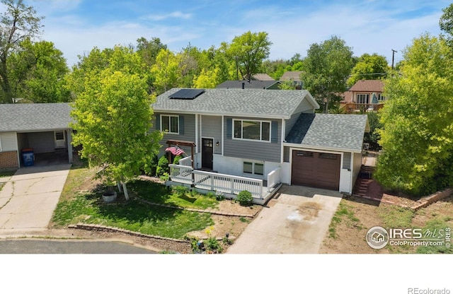 518 Whitmore Ct, Johnstown, CO 80534 - split foyer home with covered porch, a garage, driveway, roof mounted solar panels, and roof with shingles