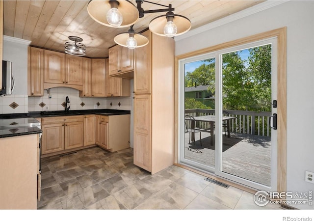 518 Whitmore Ct, Johnstown, CO 80534 - kitchen with a sink, crown molding, stainless steel microwave, backsplash, and dark countertops