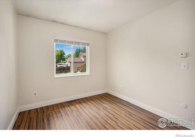 518 Whitmore Ct, Johnstown, CO 80534 - unfurnished room with wood finished floors, baseboards, and a textured ceiling