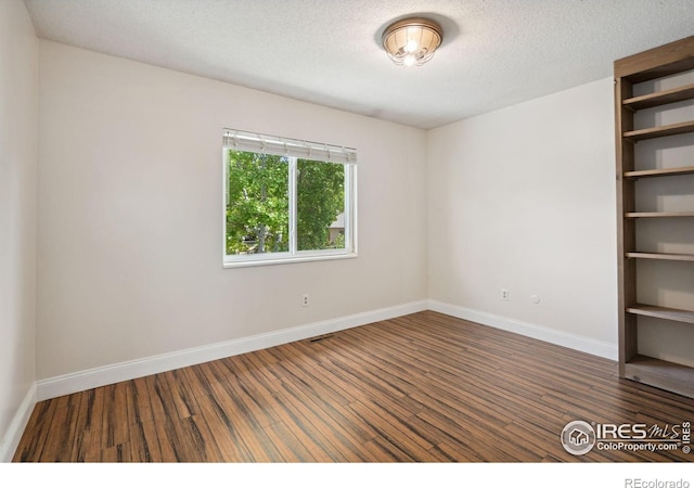 518 Whitmore Ct, Johnstown, CO 80534 - empty room with wood finished floors, baseboards, and a textured ceiling