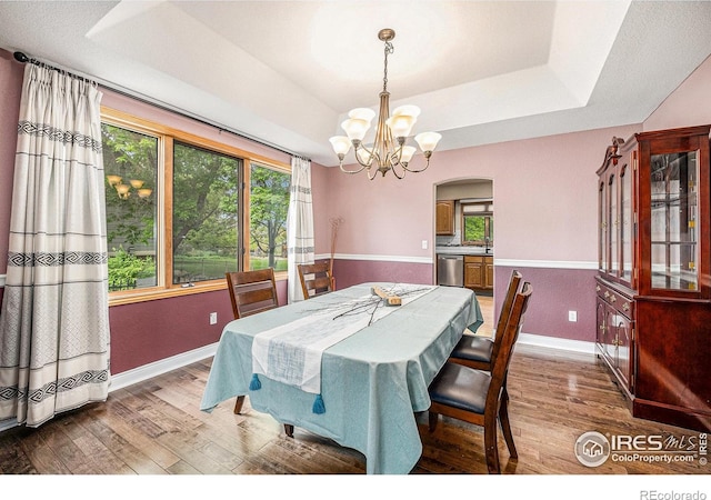 13971 Telluride Dr, Broomfield, CO 80020 - dining space featuring wood finished floors, a raised ceiling, a chandelier, and baseboards