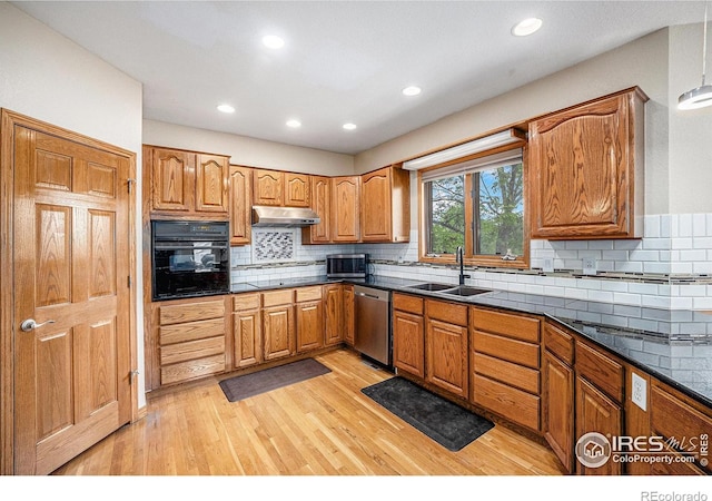 13971 Telluride Dr, Broomfield, CO 80020 - kitchen with black oven, stainless steel dishwasher, under cabinet range hood, a sink, and light wood-style flooring