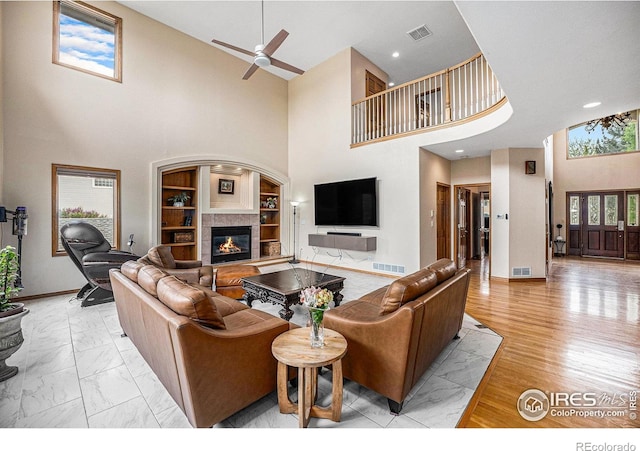 13971 Telluride Dr, Broomfield, CO 80020 - living area with a high ceiling, a fireplace, built in shelves, a ceiling fan, and baseboards