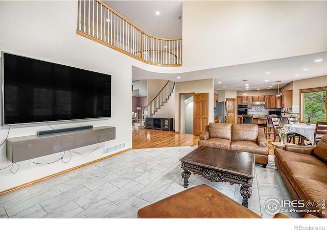 13971 Telluride Dr, Broomfield, CO 80020 - living area featuring light marble finish flooring, stairs, a towering ceiling, and recessed lighting