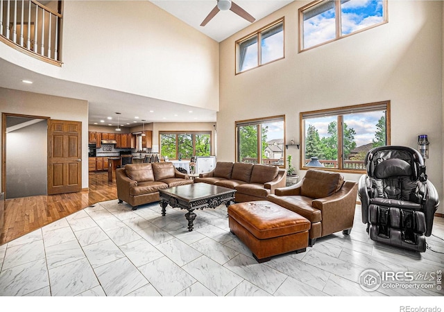 13971 Telluride Dr, Broomfield, CO 80020 - living room featuring light marble finish floors, a ceiling fan, a towering ceiling, and recessed lighting