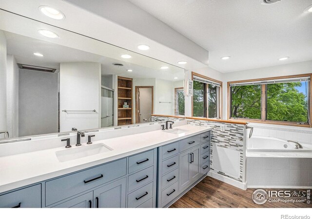 13971 Telluride Dr, Broomfield, CO 80020 - bathroom with recessed lighting, wood finished floors, double vanity, and a garden tub