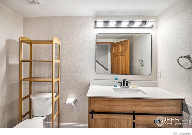 13971 Telluride Dr, Broomfield, CO 80020 - bathroom with toilet, a textured wall, vanity, and baseboards