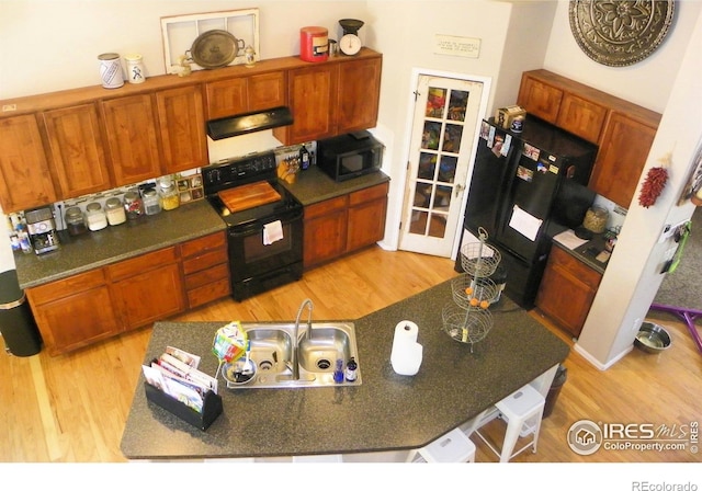 368 Mt Bross Ave, Severance, CO 80550 - kitchen with black appliances, extractor fan, light wood-style floors, and brown cabinetry