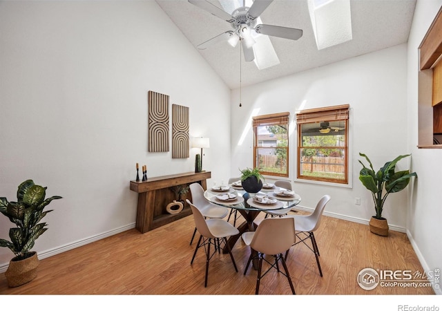 4118 Dillon Way, Fort Collins, CO 80526 - dining room featuring a skylight, ceiling fan, light wood finished floors, high vaulted ceiling, and baseboards