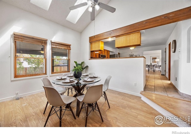 4118 Dillon Way, Fort Collins, CO 80526 - dining area with a skylight, a ceiling fan, high vaulted ceiling, light wood finished floors, and baseboards