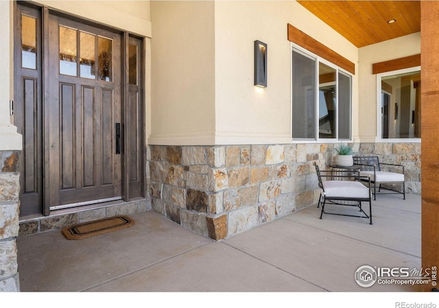 2387 Harding Park Ct, Berthoud, CO 80513 - entrance to property featuring stone siding, stucco siding, and a porch
