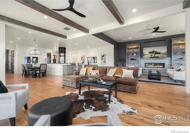 2387 Harding Park Ct, Berthoud, CO 80513 - living room featuring ceiling fan, beam ceiling, a glass covered fireplace, light wood-style flooring, and recessed lighting