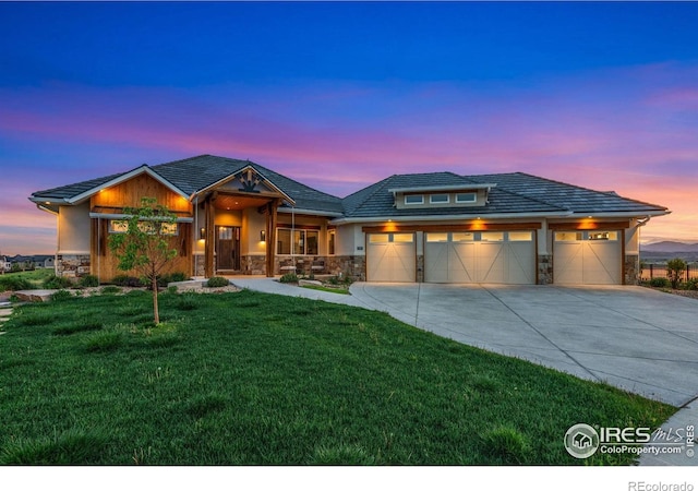 2387 Harding Park Ct, Berthoud, CO 80513 - view of front of house featuring stone siding, concrete driveway, an attached garage, and a front lawn