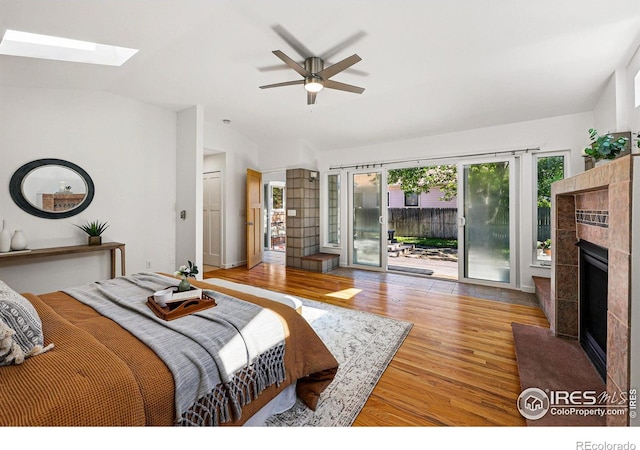 325 Colgate St, Boulder, CO 80305 - bedroom with a fireplace, access to exterior, wood finished floors, a skylight, and vaulted ceiling