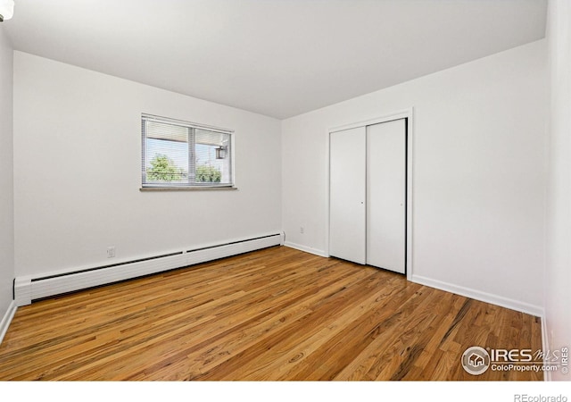 325 Colgate St, Boulder, CO 80305 - unfurnished bedroom with a baseboard heating unit, wood finished floors, a closet, and baseboards