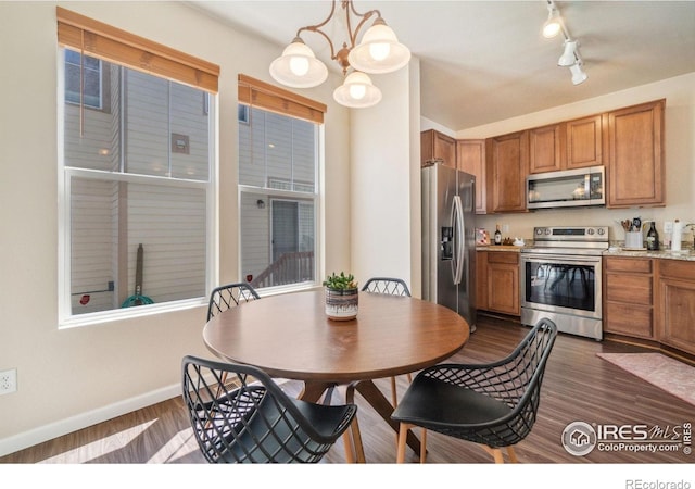 2320 Clipper Way, Fort Collins, CO 80524 - kitchen with appliances with stainless steel finishes, baseboards, brown cabinets, rail lighting, and dark wood finished floors
