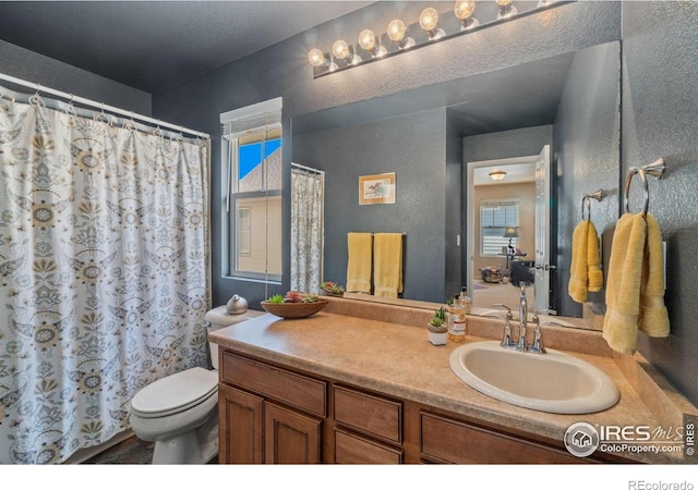 2320 Clipper Way, Fort Collins, CO 80524 - bathroom with a textured wall, vanity, toilet, and curtained shower