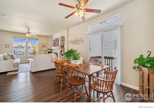 2320 Clipper Way, Fort Collins, CO 80524 - dining area with a ceiling fan, dark wood-style flooring, a fireplace, and baseboards