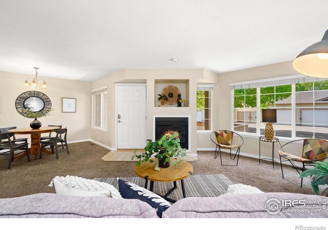 5551 Cornerstone Dr Unit 26, Fort Collins, CO 80528 - carpeted living area with baseboards, a glass covered fireplace, and a chandelier