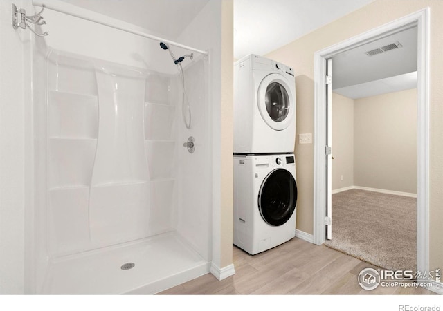 5551 Cornerstone Dr Unit 26, Fort Collins, CO 80528 - bathroom featuring stacked washer and clothes dryer, wood finished floors, a shower stall, and baseboards
