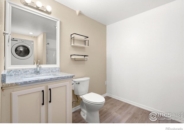 5551 Cornerstone Dr Unit 26, Fort Collins, CO 80528 - bathroom featuring washer / clothes dryer, wood finished floors, toilet, baseboards, and vanity