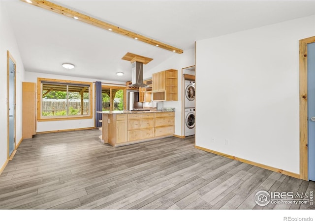 1805 Kinnikinnik Pl, Loveland, CO 80537 - kitchen featuring stacked washing machine and dryer, island exhaust hood, open shelves, light wood-style flooring, and light brown cabinetry