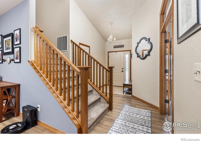 6848 Pettigrew St, Wellington, CO 80549 - foyer featuring light wood finished floors, a chandelier, stairs, lofted ceiling, and baseboards