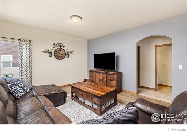 6848 Pettigrew St, Wellington, CO 80549 - living area with arched walkways, wood finished floors, and baseboards