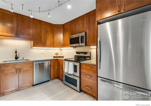 4795 Tantra Dr, Boulder, CO 80305 - kitchen featuring stainless steel appliances, a sink, brown cabinets, light countertops, and light wood finished floors