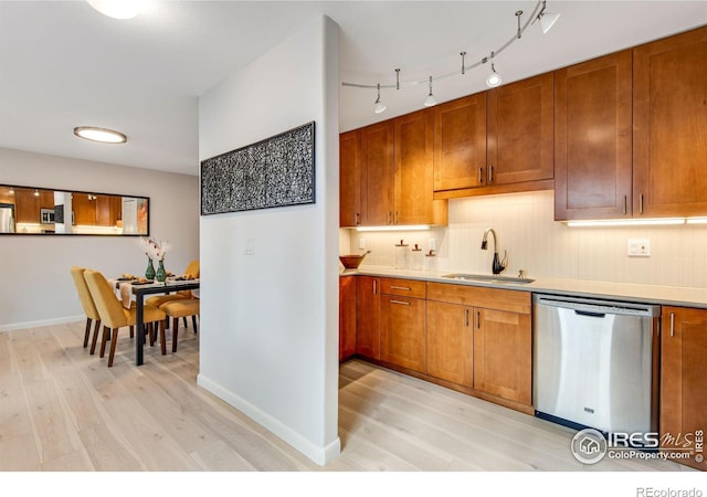 4795 Tantra Dr, Boulder, CO 80305 - kitchen with a sink, stainless steel dishwasher, light wood-style floors, and brown cabinets