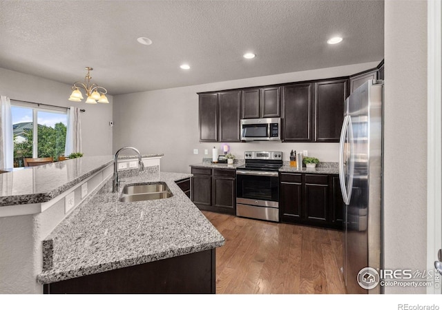 6681 6th St, Frederick, CO 80530 - kitchen featuring appliances with stainless steel finishes, a sink, a chandelier, light wood-style flooring, and recessed lighting