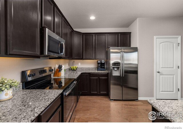 6681 6th St, Frederick, CO 80530 - kitchen featuring appliances with stainless steel finishes, light wood-style floors, light stone countertops, dark brown cabinets, and recessed lighting