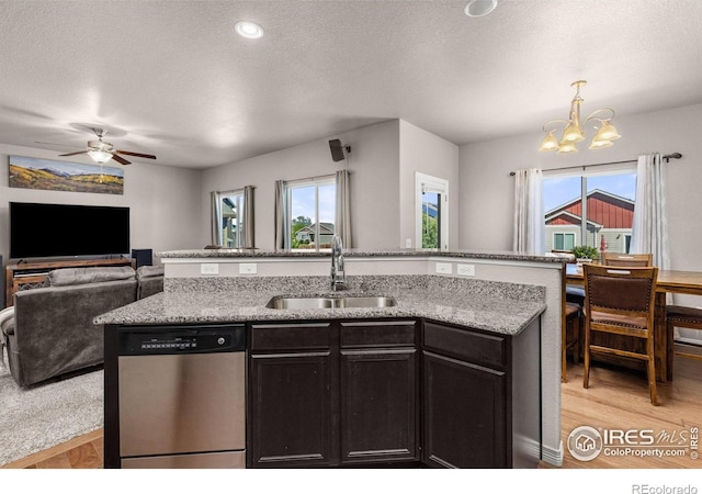 6681 6th St, Frederick, CO 80530 - kitchen with stainless steel dishwasher, a sink, a chandelier, open floor plan, and light wood-type flooring