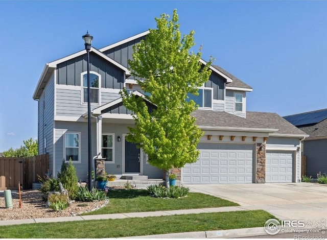 6681 6th St, Frederick, CO 80530 - view of front of home with board and batten siding, driveway, a garage, and stone siding