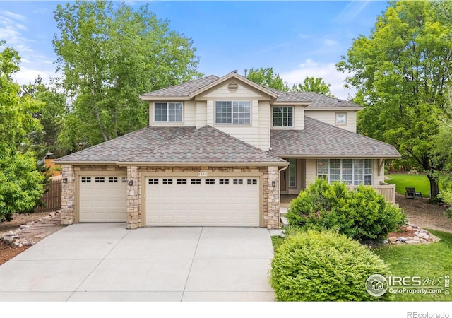5348 Wild Dunes Ct, Boulder, CO 80301 - traditional-style house featuring a garage, driveway, roof with shingles, and stone siding