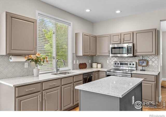 5348 Wild Dunes Ct, Boulder, CO 80301 - kitchen with appliances with stainless steel finishes, a sink, gray cabinets, decorative backsplash, and a center island