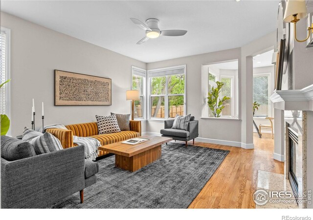 5348 Wild Dunes Ct, Boulder, CO 80301 - living area featuring light wood-type flooring, a ceiling fan, baseboards, and a premium fireplace