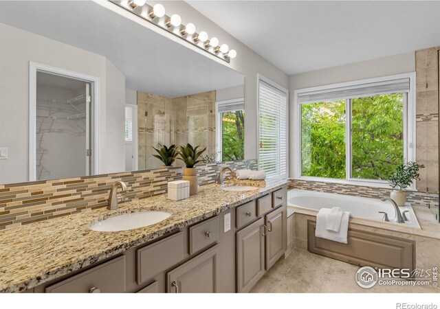 5348 Wild Dunes Ct, Boulder, CO 80301 - bathroom featuring tasteful backsplash, tiled shower, a bath, double vanity, and tile patterned floors