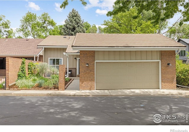 4924 Clubhouse Ct, Boulder, CO 80301 - view of front facade with brick siding, board and batten siding, a tile roof, and a garage