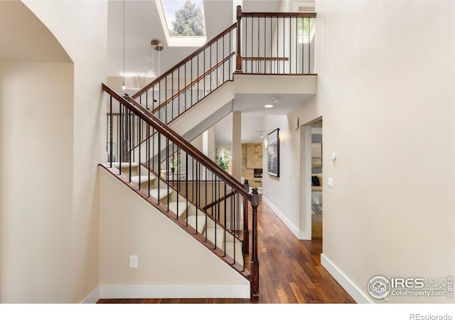 4924 Clubhouse Ct, Boulder, CO 80301 - stairs featuring baseboards, hardwood / wood-style floors, a high ceiling, and arched walkways