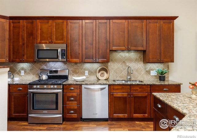 4924 Clubhouse Ct, Boulder, CO 80301 - kitchen featuring appliances with stainless steel finishes, a sink, light stone countertops, dark wood-style floors, and decorative backsplash