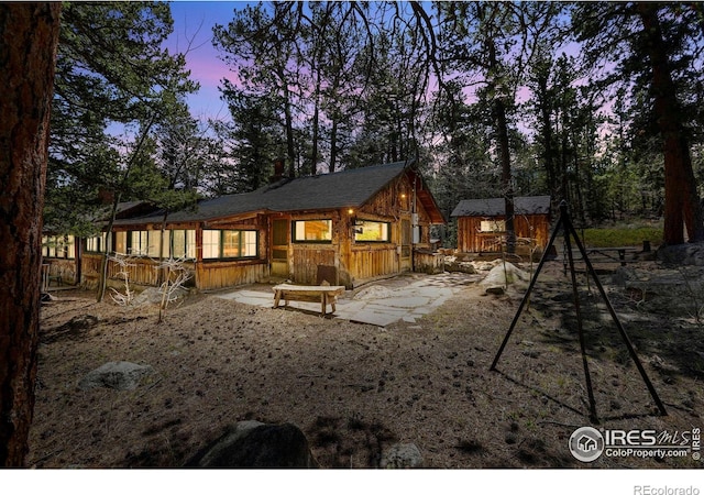 12991 Peak To Peak Hwy, Allenspark, CO 80510 - back of house at dusk with an outbuilding