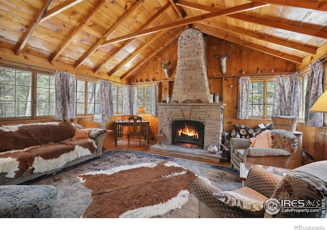 12991 Peak To Peak Hwy, Allenspark, CO 80510 - living room with wood ceiling with exposed beams, wood finished floors, wooden walls, a fireplace, and high vaulted ceiling