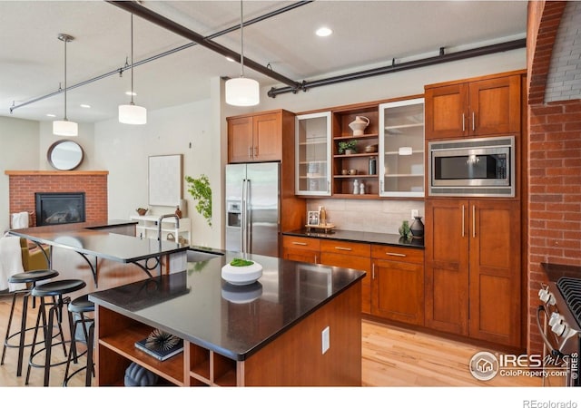 1203 High St, Boulder, CO 80304 - kitchen with appliances with stainless steel finishes, open shelves, light wood finished floors, dark countertops, and a kitchen breakfast bar